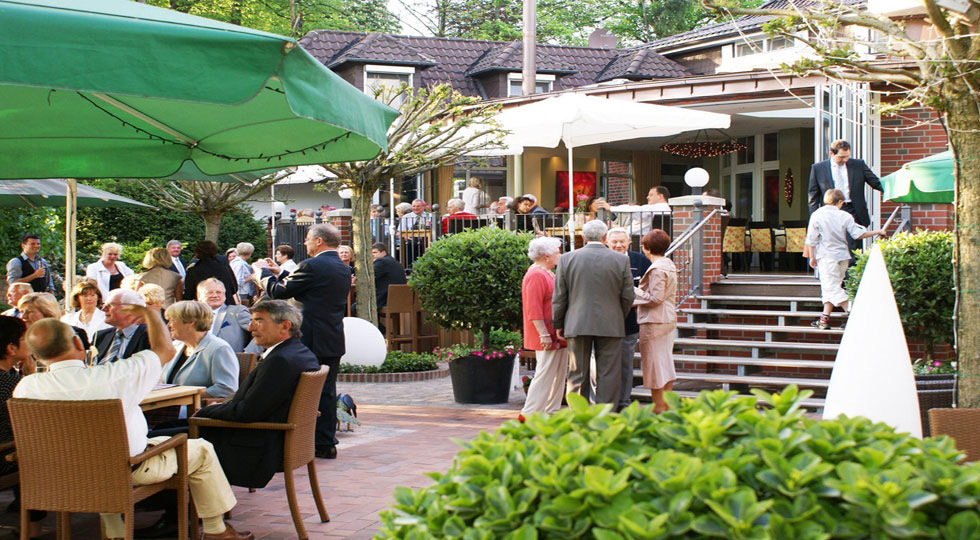 Guests in the summer garden of Hotel Robben under parasols